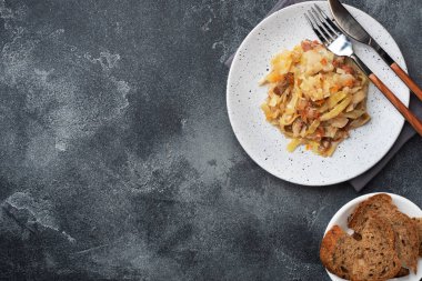 Tabağında et olan haşlanmış lahana. Koyu beton arka plan. Boşluğu kopyala