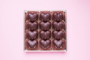 Sevgililer Günü kavramı. Çikolatalı şekerler, pembe arka planda kalpler.