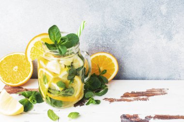 Limonata bardak maden suyu, limon ve nane kavanoza ışık arka plan üzerinde bırakır. Kopya alanı