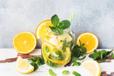 Limonata bardak maden suyu, limon ve nane kavanoza ışık arka plan üzerinde bırakır. Kopya alanı