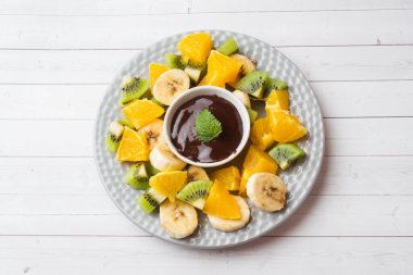 Beyaz masada meyve ile çikolata fondü. kavram yaz partisi. Kopyalama alanı