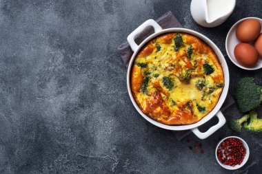 Seramik tabakta brokoli ve fırında omlet. Koyu beton masa. Uzayı kopyala Sağlıklı beslenme yemeği..