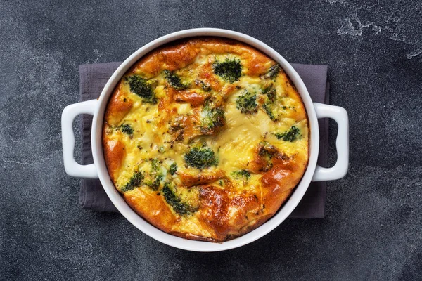 Pečená omeleta s brokolicí v keramické míse. Tmavý betonový stůl. Rozumím. Zdravá strava jídlo misky. — Stock fotografie