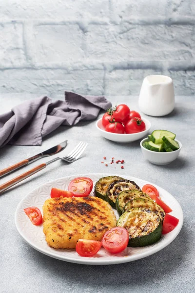 Schnitzel of chicken and zucchini cooked on the grill. Fresh tomatoes on a plate. Ready delicious dinner lunch. Copy space.