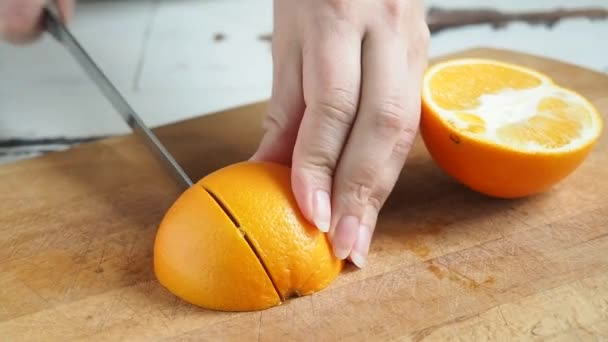 Kvinna skära orange på trä styrelse hem kök. Användbar hälsosam mat frukter citrus. — Stockvideo