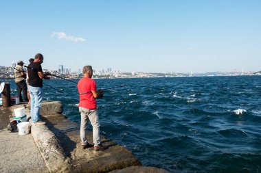 İstanbul, Türkiye - 05 Eylül 2019: İstanbul 'da İstanbul Boğazı kıyısında balık tutan insanlar