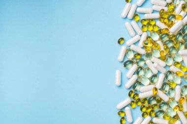 Tabletler mavi zemin üzerinde beyaz ve sarıdır. İlaçlar vitamin ilaçları