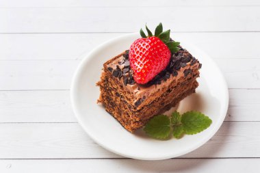 Beyaz ahşap bir masa üzerinde çikolata ve çilek ve nane ile Trüf kek. Seçici odak Kopyalama alanı