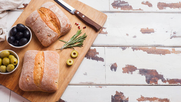 Italian ciabatta bread with olives and rosemary on a wooden Board Copy space