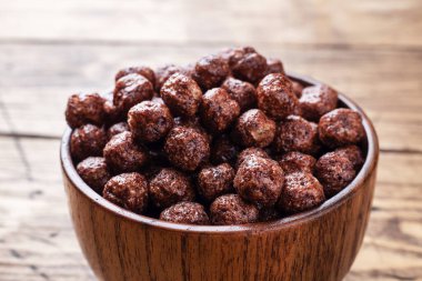 Doğal mısır gevreğindeki çikolata taneleri sütlü kahvaltı için kurutuldu. Tahta tablo Boşluğu kopyala