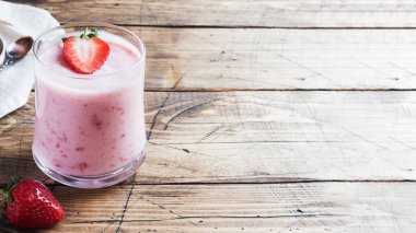 Ahşap bir arka plan üzerinde gözlük taze çilek ile ev yapımı yoğurt. Seçici odak. Kopyalama alanı