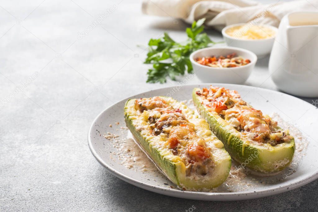 Baked stuffed zucchini boats with minced chicken mushrooms and vegetables with cheese on a plate Copy space