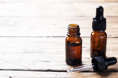 Ahşap arka planda pipetli bir şişe kozmetik yağı. Uzayı kopyala Seçici odak