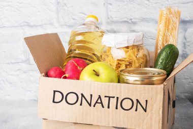 Kutuda toplanan yiyecek bağışı. Gri arka plan. Boşluğu kopyala
