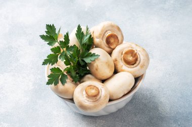 Maydanozlu tabak içinde çiğ mantar şampiyonları. Boşluğu kopyala