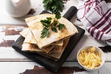 Tahta tezgahta maydanoz yapraklı peynirli, mantarlı Quesadilla parçaları. Ahşap arkaplan kopyalama alanı