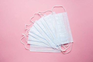 Tek kullanımlık tıbbi yüz maskeleri. Virüsün önlenmesi kavramı. Pembe arka plan. Boşluğu kopyala