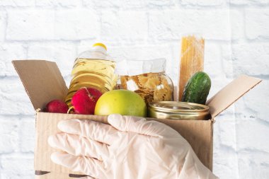 Kutuda toplanan yiyecek bağışı. Gri arka plan. Boşluğu kopyala