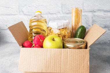 Kutuda toplanan yiyecek bağışı. Gri arka plan. Boşluğu kopyala