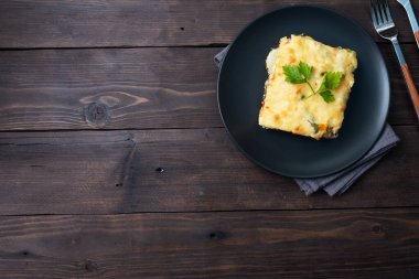 Peynirli patates ve sebzeli güveç. Koyu ahşap arka plan. Boşluğu kopyala