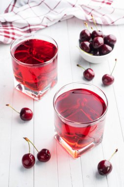 Bardakta kiraz suyu ve taze kiraz meyvesi. Beyaz arka plan. Boşluğu kopyala