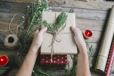 Noel hediyelerini ahşap masa arka planda tutan adam