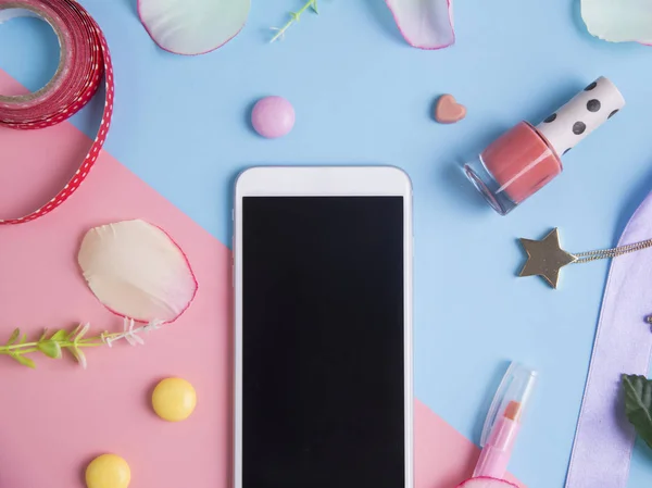 Smartphone with pink petals on pastel background. — Stock Photo, Image