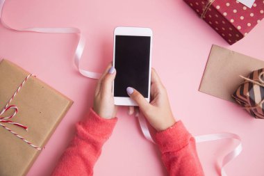 Kadın pembe bir arka plan üzerinde kullanma smartphone el.