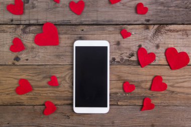 ahşap masa üzerinde kırmızı kalp ile Smartphone