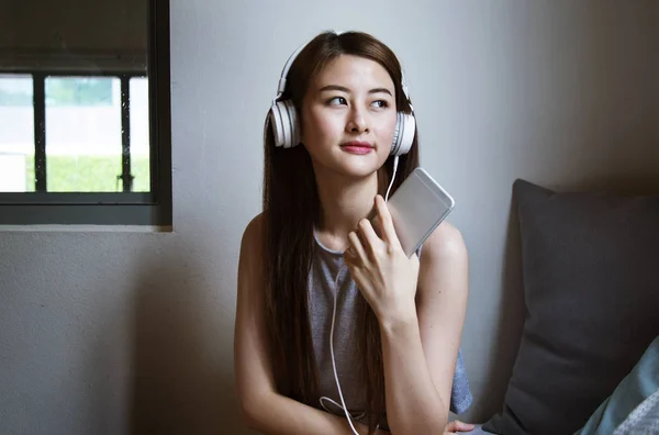 Jeune asiatique femme écoute musique — Photo