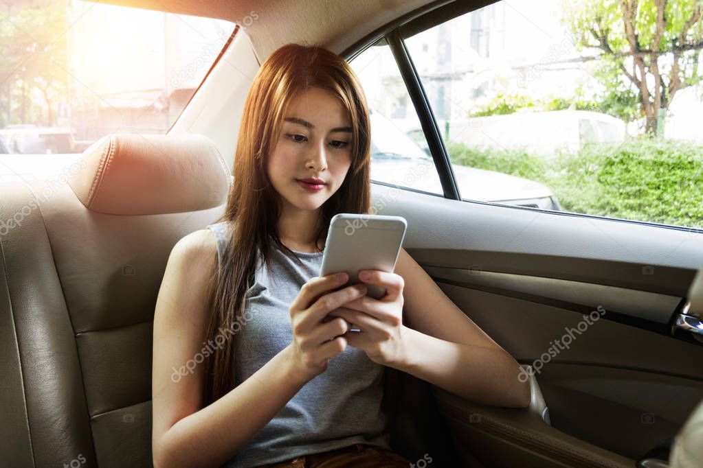 Young asian woman use smartphone in car