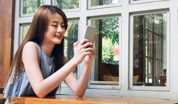Les femmes asiatiques utilisent un smartphone dans un café . — Photo