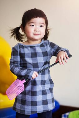 Biraz güzel Asyalı çocuk oyuncak sevinçle oynarken