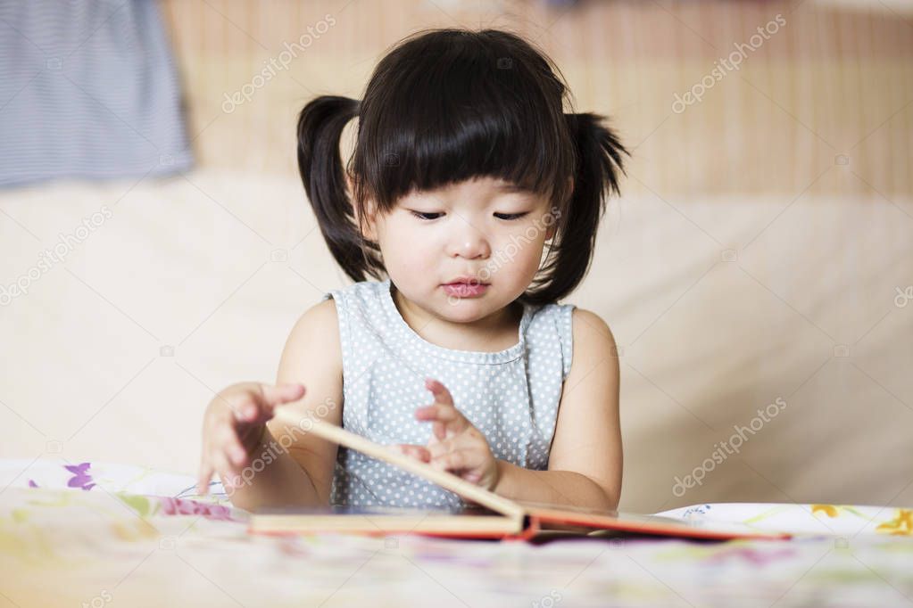Charming and lovely asian kid reading book 