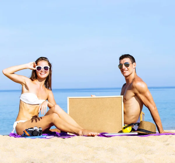 Ett trevligt par bär solglasögon och leende på havet i sommar — Stockfoto