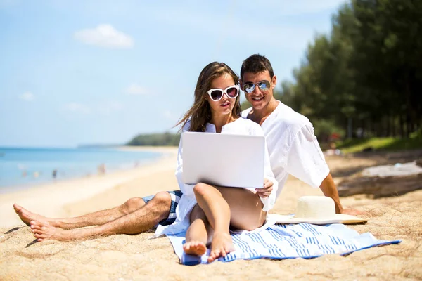 Para gra laptopa szczęśliwie na pięknej plaży w okresie letnim — Zdjęcie stockowe