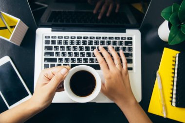 Kahve fincanı tutarak ve ofiste tipik klavye 