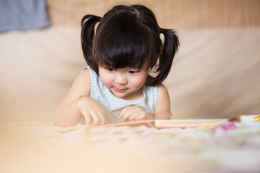 Sevimli ve güzel Asyalı çocuk kitap okumaya konsantre