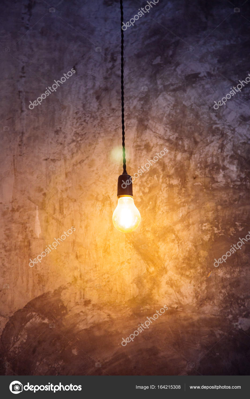 Light bulb hanging from ceiling with illumination Stock Photo by