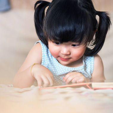 Sevimli ve güzel Asyalı çocuk kitap okumaya konsantre