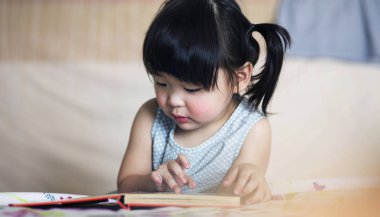 Sevimli ve güzel Asyalı çocuk kitap okumaya konsantre