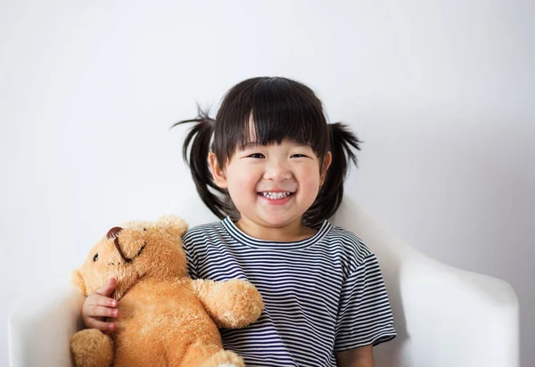 Çok güzel ve masum Asyalı çocuk teddy ile mutlu bir şekilde gülümsedi