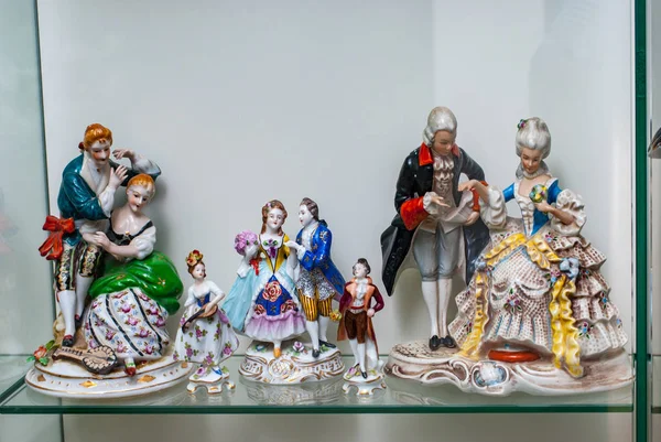 Surtido de figuras raras de porcelana en estante de vidrio — Foto de Stock