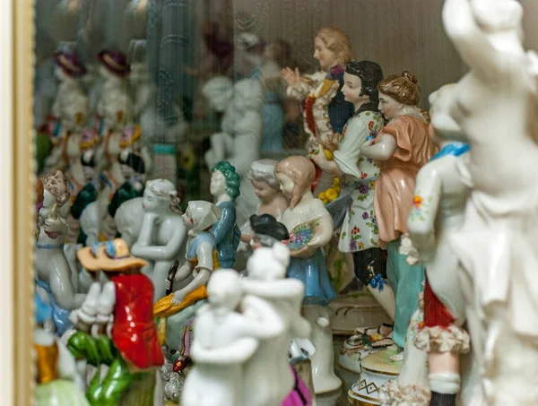 Surtido de figuras raras de porcelana en estante de vidrio — Foto de Stock