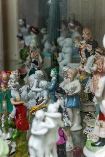 Assortment of rare porcelain figurines on glass shelf — Stock Photo, Image