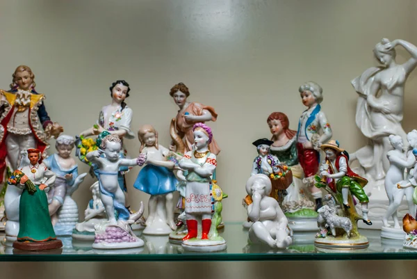 Sortimento de figuras de porcelana rara na prateleira de vidro — Fotografia de Stock