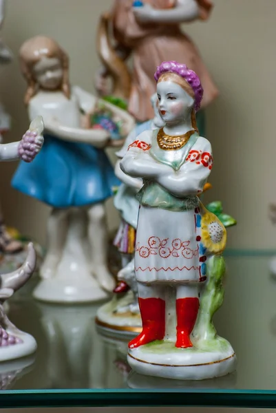 Asortyment rzadkich figurek porcelanowych na półce szklanej — Zdjęcie stockowe