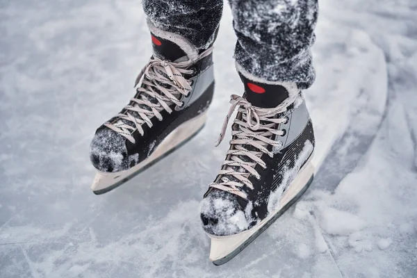 Hockey skates on the player feet after ice hockey. Close-up