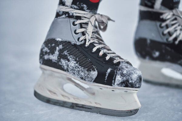 Хоккейные коньки на ногах игрока после хоккея. Крупный план
