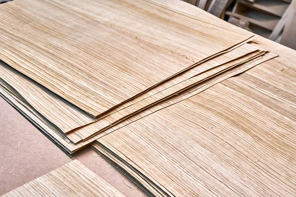 Oak veneer. Oak texture. Spliced oak veneer on the table in the workshop. Close-up